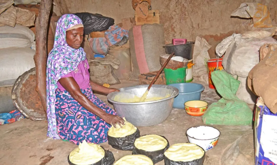 A woman processing shea butter by hand in Northern Ghana